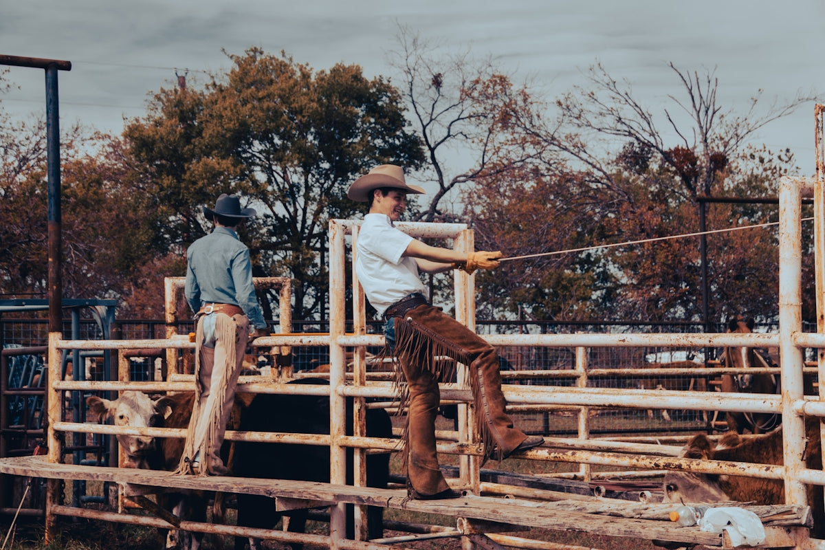 a couple of men standing on top of a wooden fence