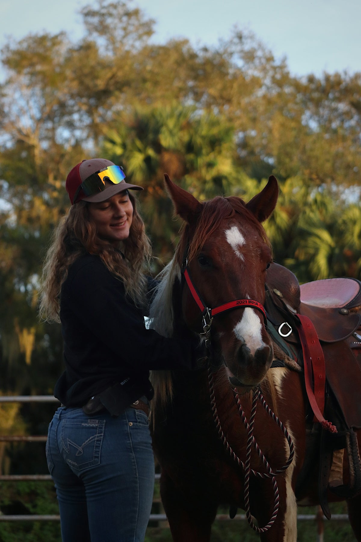 a woman standing next to a brown and white horse