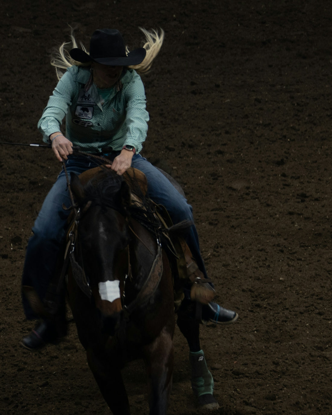A cowgirl rides a horse in a rodeo