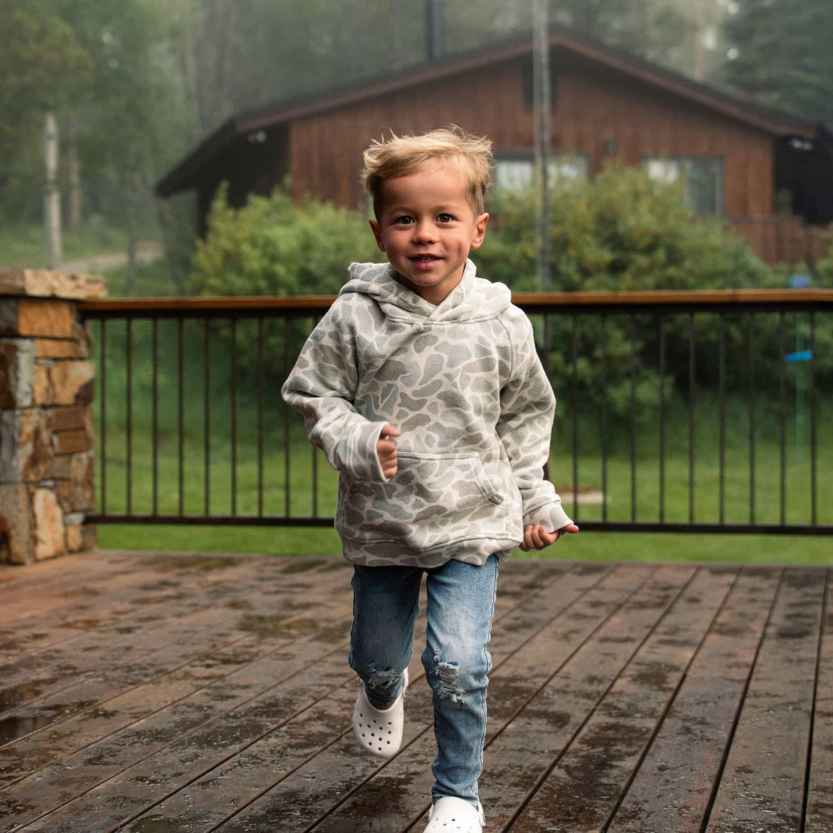 Youth wearing Classic Deer Camo vintage washed hoodie outdoors